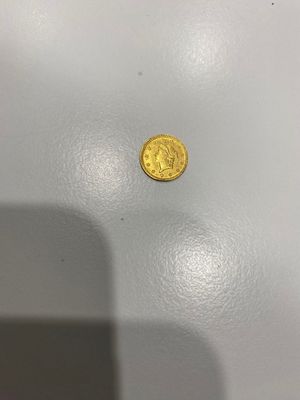 une pièce d'or posée sur une table blanche