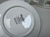 a white plate sitting on a table next to a cup and saucer