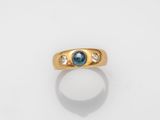 an image of a gold ring with a blue sapphire and diamonds