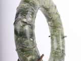 a green ring on a metal stand on a white background
