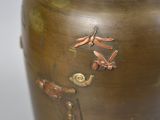 a vase with dragonflies on it sitting on a table