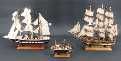 trois maquettes de bateaux exposées sur une table