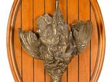 a wooden plaque with a bird on it on a wall