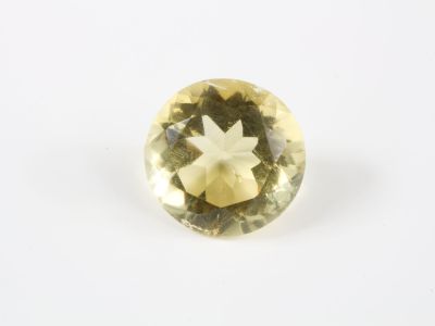 gros plan d'une pierre de saphir jaune sur une surface blanche