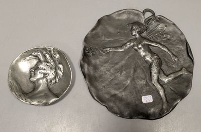 a silver plate with a picture of a woman on it next to a silver coin