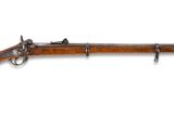 un vieux fusil accroché au mur, avec un canon en bois