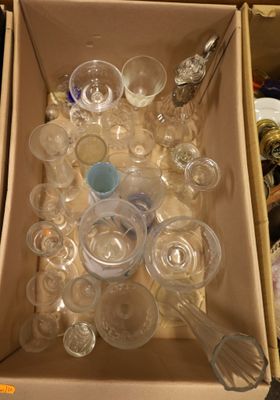 une boîte remplie de gobelets et de cuillères en plastique vides