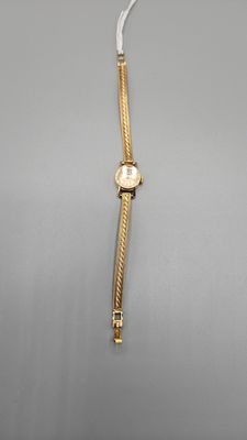 an image of a gold watch on a gray background