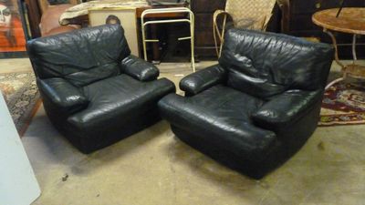 deux fauteuils en cuir noir placés l'un à côté de l'autre dans une pièce
