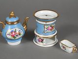 a small tea pot and a tea cup on a saucer