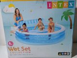 three children sitting in an inflatable pool with a palm tree