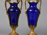 pair of blue glass vases with gold accents on stands