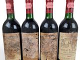 three bottles of red wine are lined up on a white surface