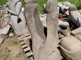 un tas de statues en pierre posées sur une palette dans la cour