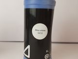 blue bottle of ink sitting on a white surface next to a white wall