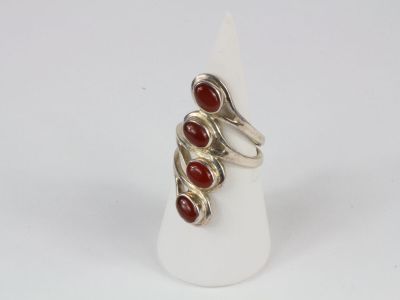 a close up of a silver ring with red stones on it