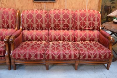 un canapé rouge et deux fauteuils dans une pièce