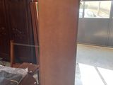 a tall wooden cabinet in the middle of a room