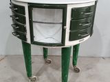 une commode verte et blanche à tiroirs, montée sur roulettes