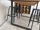 a wooden table with four stools in front of it