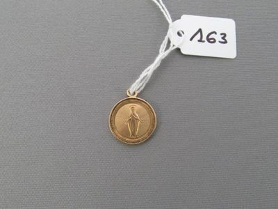 une médaille d'or avec la photo d'une femme dessus