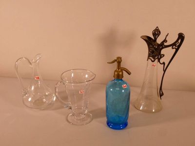 trois vases en verre et une bouteille posés sur une table