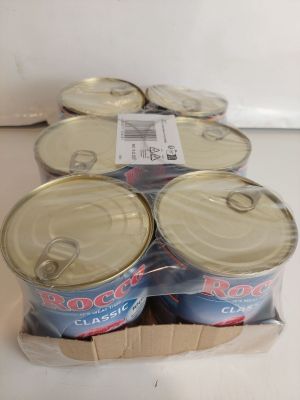 six canettes de soda posées dans une boîte en carton sur un comptoir