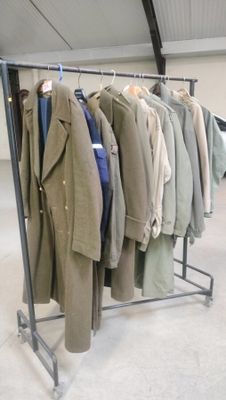 a lot of coats hanging on a rack in a room