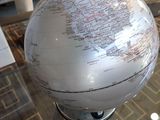 un globe blanc posé sur une table en verre dans un salon