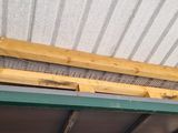 the roof of a building with a metal roof and wooden beams