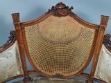 a wicker chair with a wooden frame and a wicker seat
