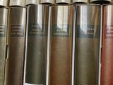 several old books are lined up on a shelf in a library