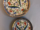 three plates with floral designs on them are sitting on a table