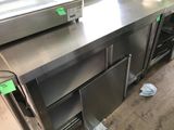 stainless steel counter top in a commercial kitchen with a refrigerator and freezer