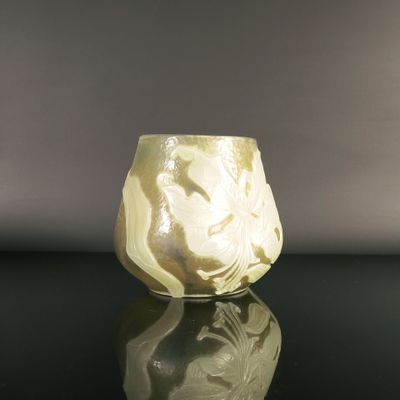 a white vase sitting on top of a black table