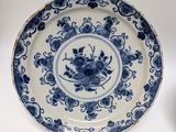a blue and white plate with a flower design on it