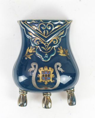 a blue vase with a gold decoration on it