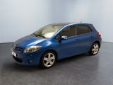 La Toyota Yaris bleue est garée dans une grande pièce.