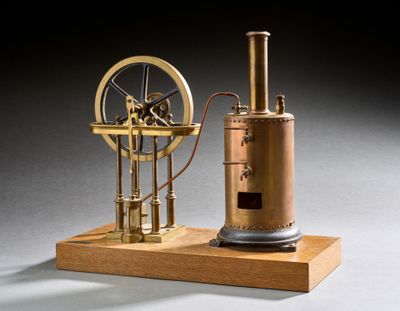 une image représentant une maquette de machine à vapeur posée sur un socle en bois