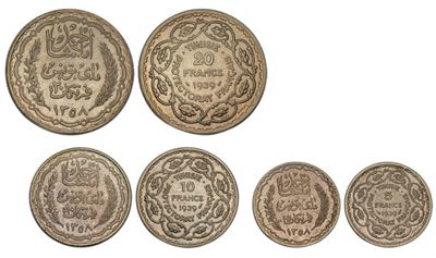a group of five different coins with arabic writing on them