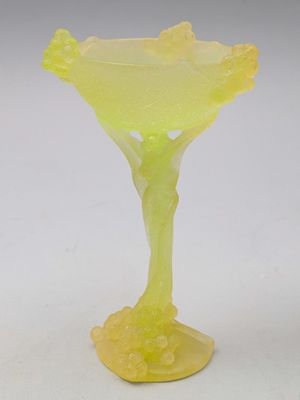 vase en verre jaune posé sur une surface blanche, avec un fond blanc