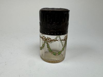 a small glass jar with a black lid on a white surface