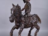 statue représentant un homme à cheval, portant une caisse sur le dos