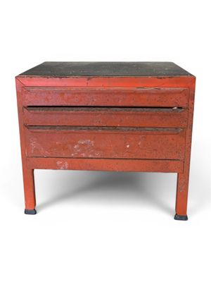 une vieille commode rouge sur fond blanc