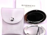 a compact mirror and a case on a white table