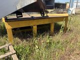 a yellow bench sitting in the grass next to a building