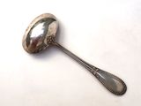 a silver spoon with a spoon handle on a white surface