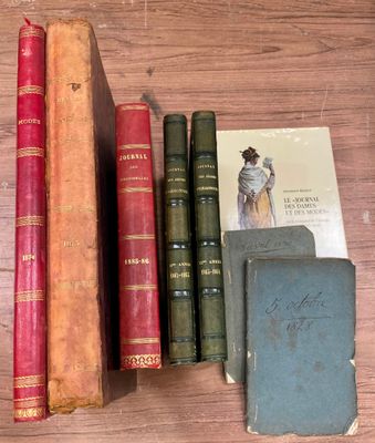 Plusieurs vieux livres sont posés sur une table en bois à côté d'un livre