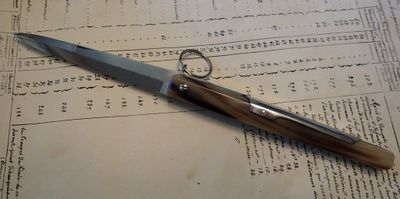 un couteau posé sur une feuille de papier