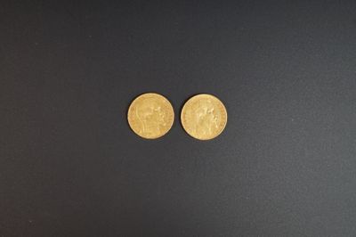 gros plan de deux pièces d'or sur une surface noire